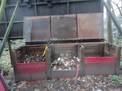 a pinkish-red 3 bay composting system, with lids open, exposing the composting processes inside.